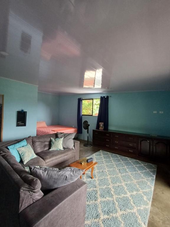 a living room with two couches and a blue wall at House la Rosa third floor 5 in Quepos