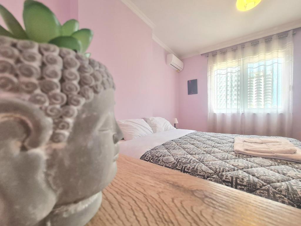a bedroom with a statue of a head on a bed at Sandra's Apartment in Tirana Center in Tirana