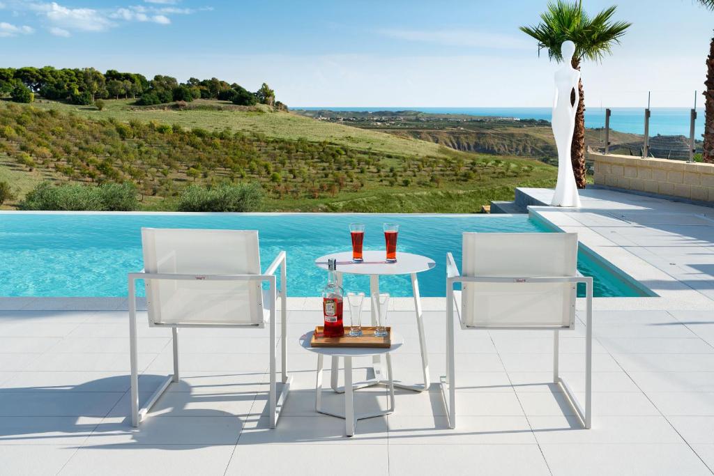 a table and two chairs next to a swimming pool at Camemi in Seccagrande