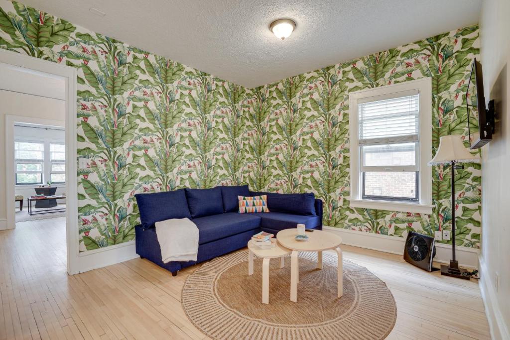 a living room with a blue couch and floral wallpaper at Minneapolis Vacation Rental - 1 Mi to Downtown! in Minneapolis