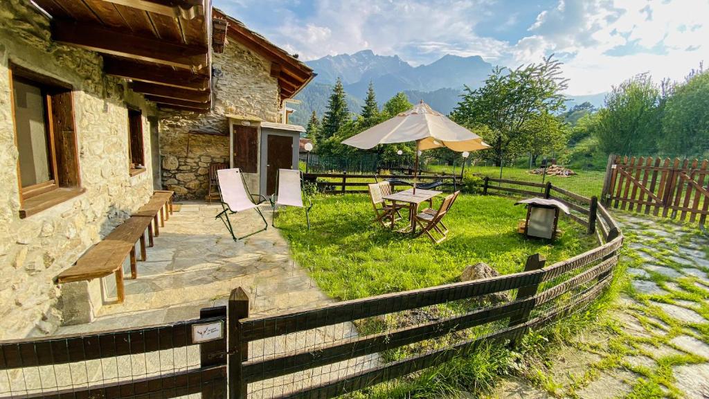 eine Terrasse mit einem Tisch und einem Sonnenschirm in der Unterkunft La casa di Tommy in Savoulx