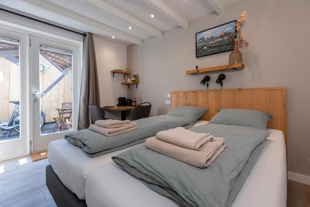 a bedroom with two beds with towels on them at Bed & Bike Schoudieck in Den Burg