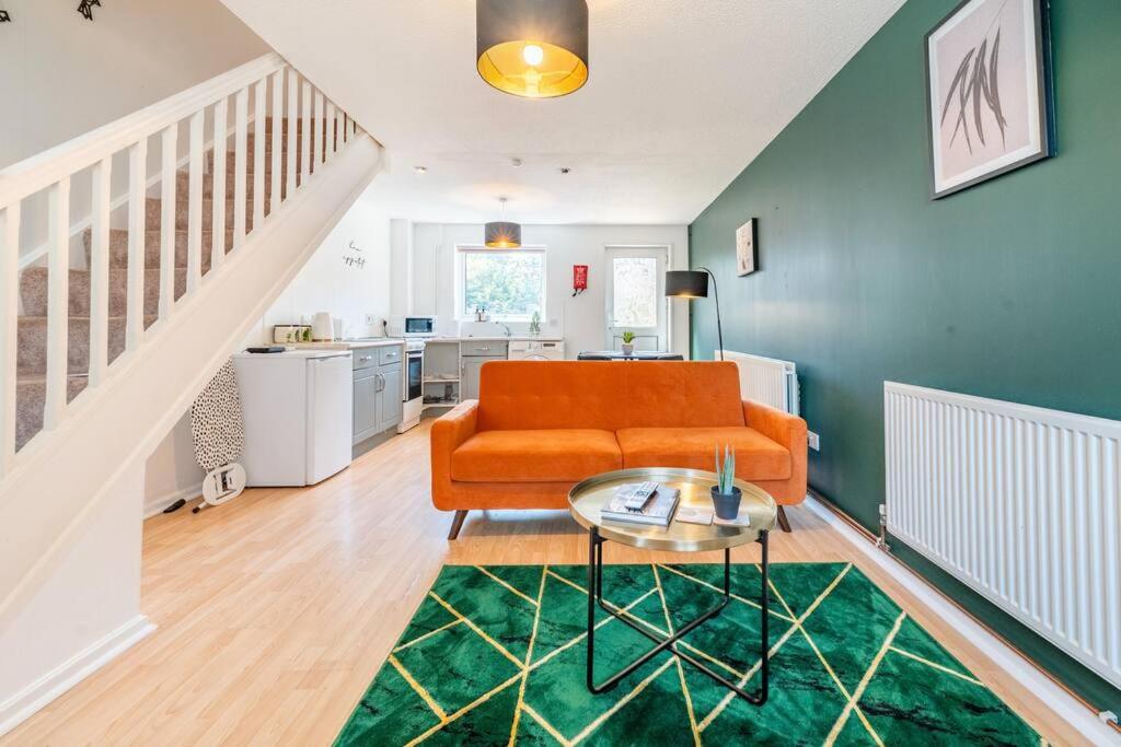 a living room with an orange couch and a table at Cosy, Conveniently Located House by Dwell Haven - Close to Cardiff centre in Cardiff