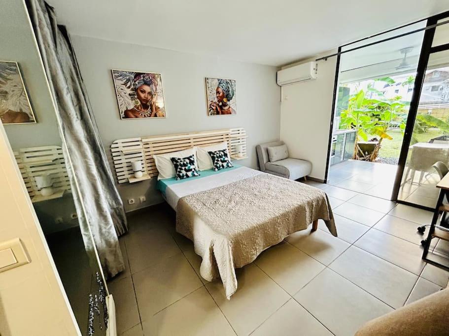 a bedroom with a bed and a balcony at Studio cosy plage et piscine à Bas Du Fort in Le Gosier