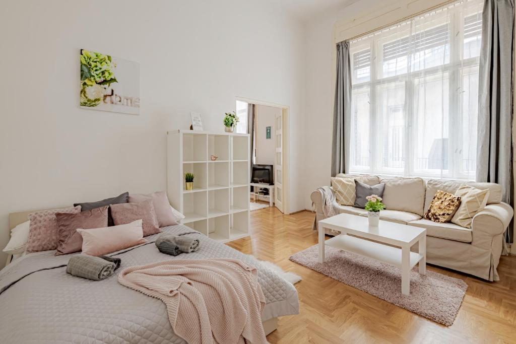 a white bedroom with a bed and a couch at Vintage Home next to Central Market Hall in Budapest