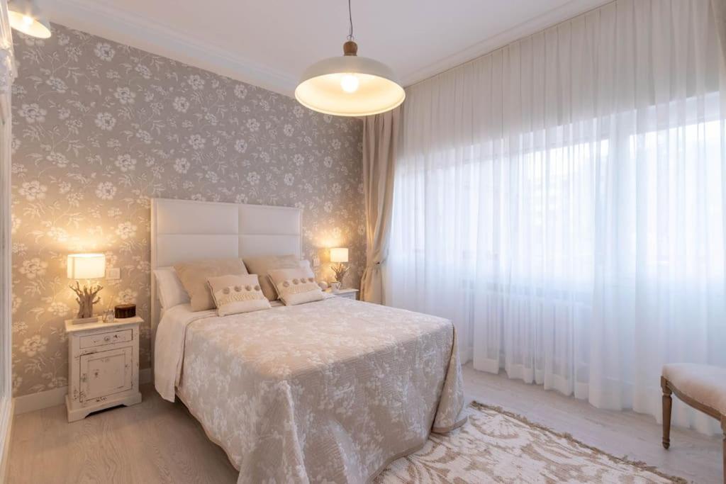a bedroom with a bed and a large window at Apartamento LUXURY centro Bilbao GARAJE in Bilbao