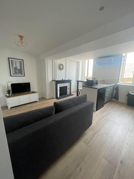 un salon avec un canapé et une table dans l'établissement appartement 2 neuf climatisée, à Blaye