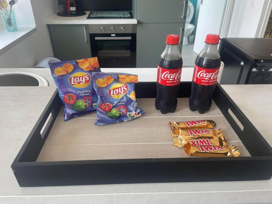 a tray with two bottles of soda and snacks on a counter at appartement 2 neuf climatisée in Blaye