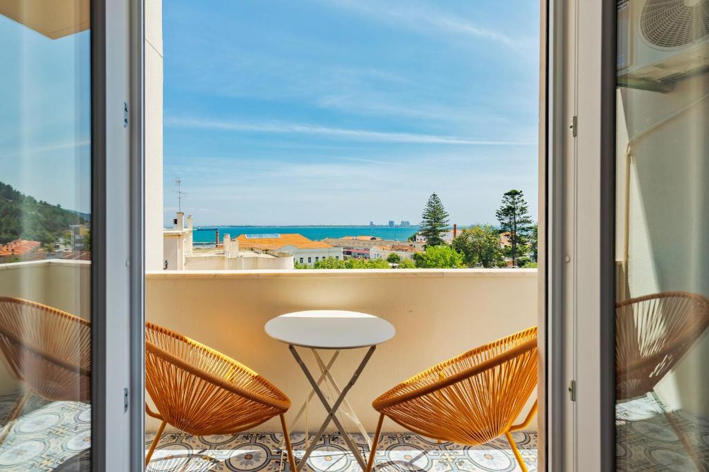 a balcony with a table and chairs and a view of the ocean at Castle View in Setúbal