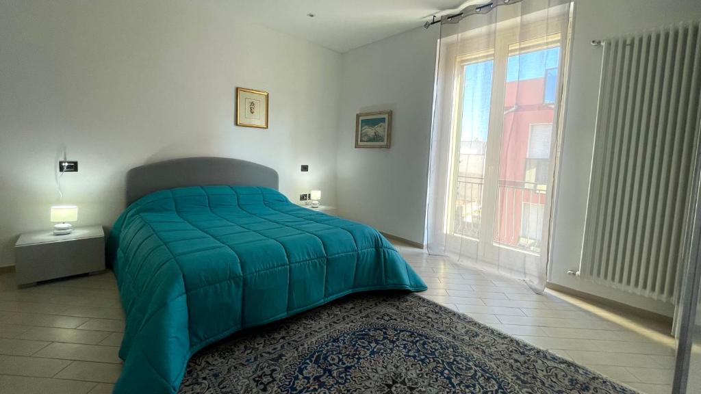 ein Schlafzimmer mit einem Bett mit einer grünen Bettdecke und einem Fenster in der Unterkunft Refrésh House in Brindisi