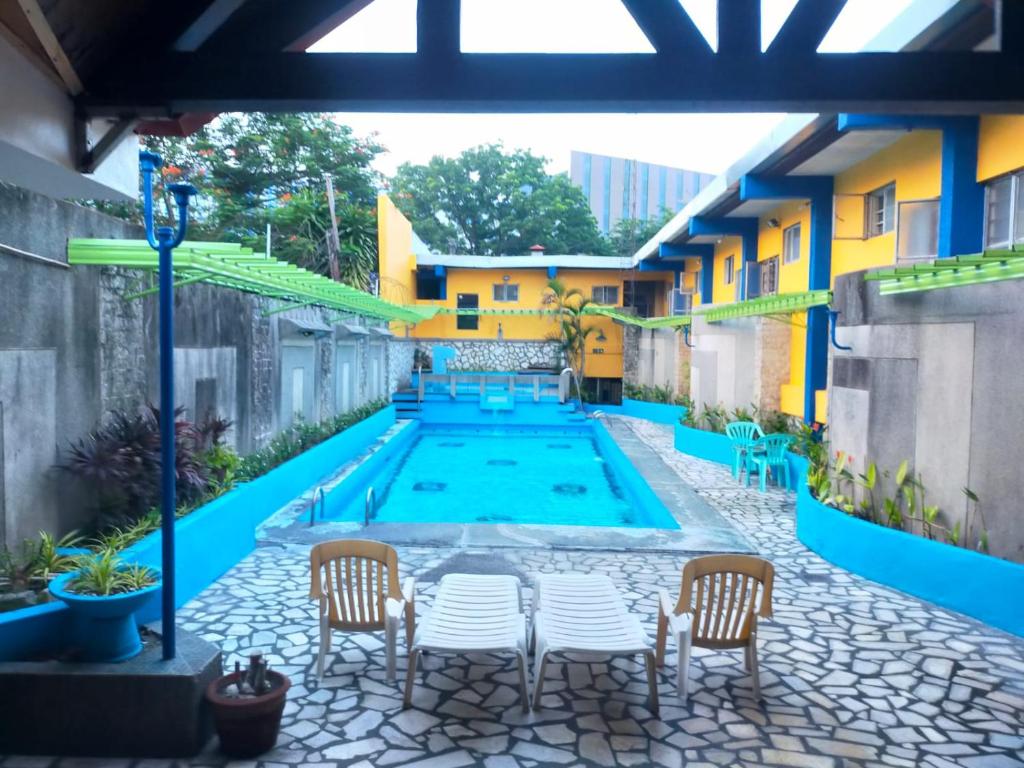 a pool in the courtyard of a building with chairs at 2 Hotel Saleh in Angeles