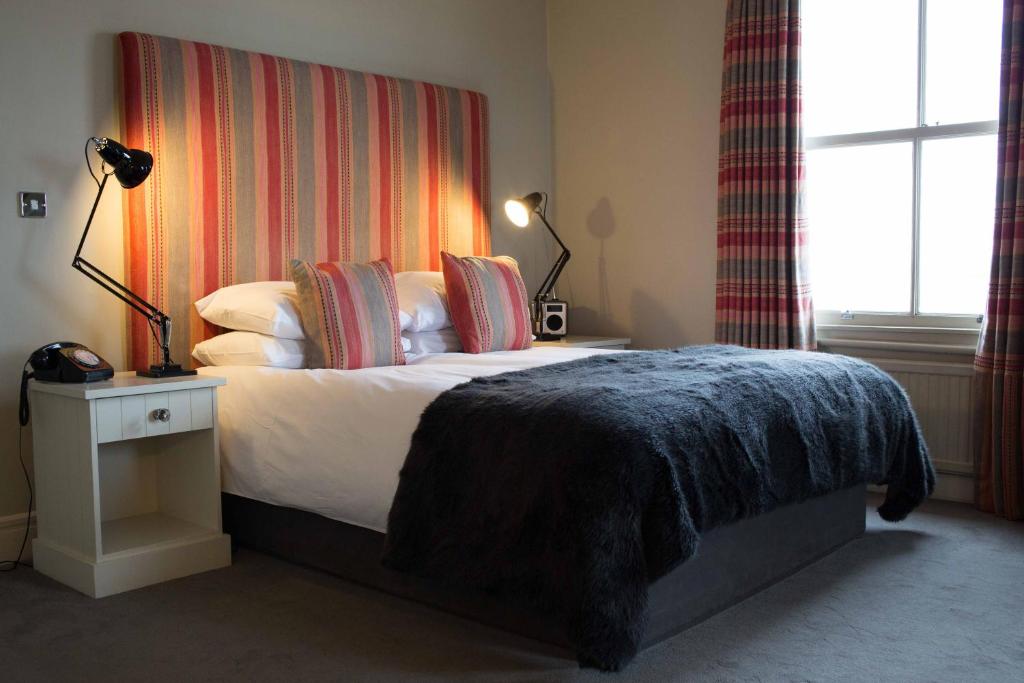 a bedroom with a bed with a blanket on it at The Pier Hotel in Harwich