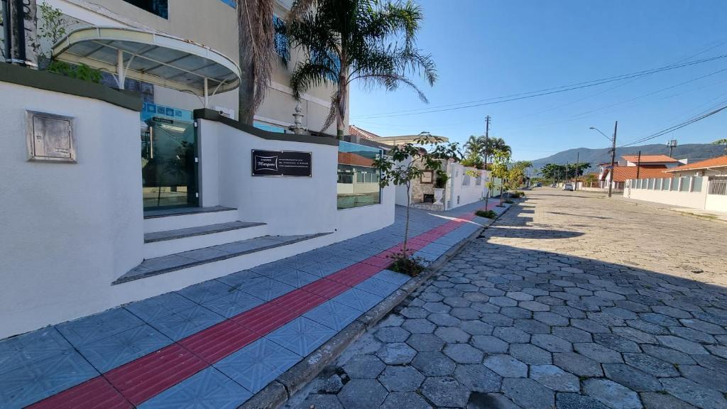 a building with a red stripe on the side of a street at Pousada Marques Floripa in Florianópolis