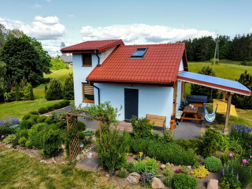 una pequeña casa blanca con techo rojo en Domek Mazurski Chill, en Jakubowo