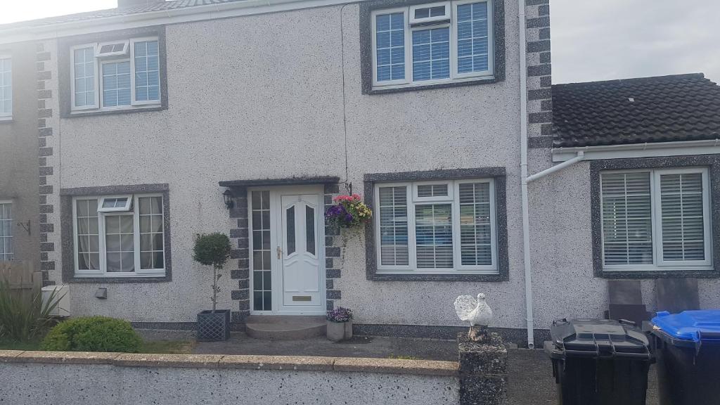 a gray house with a white door and windows at 31 riverside in Great Clifton