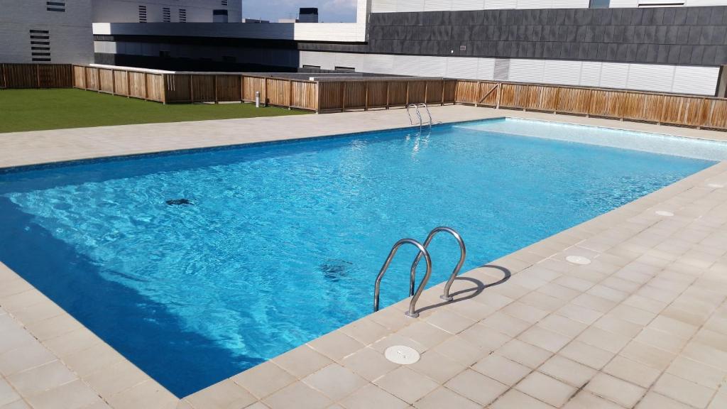 una gran piscina de agua azul en un edificio en Apartment Airport Barcelona Premium en Viladecans