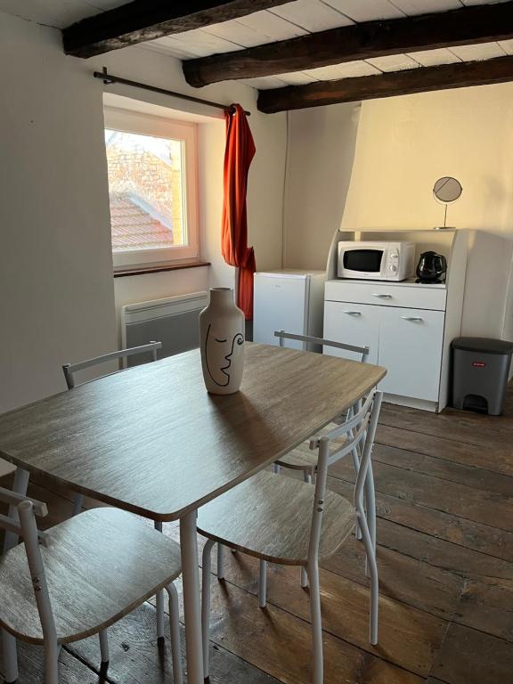 cocina con mesa de madera y sillas y cocina con mesa en Studio, chambre privée, en Langres