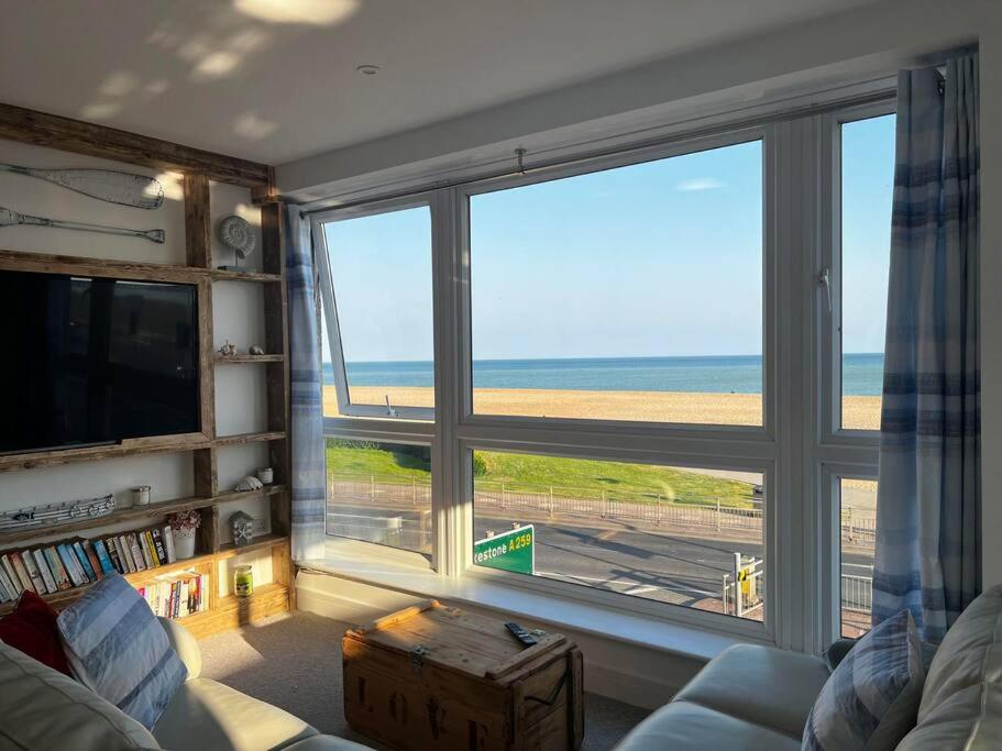 a living room with a large window with a view of the beach at Beachfront retreat apartment with amazing terrace in Hastings