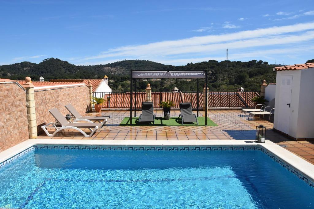 una piscina con 2 sillas y un cenador en SIERRA LAGO en Córdoba