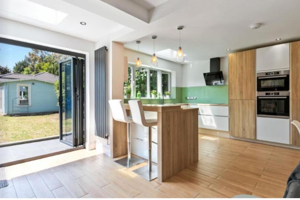 a kitchen with a counter and a large window at Large family home near Richmond Park in New Malden