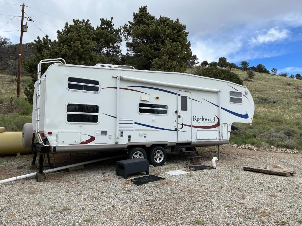 un remolque blanco está estacionado en un campo en Private Camper on Working Ranch, en Salida