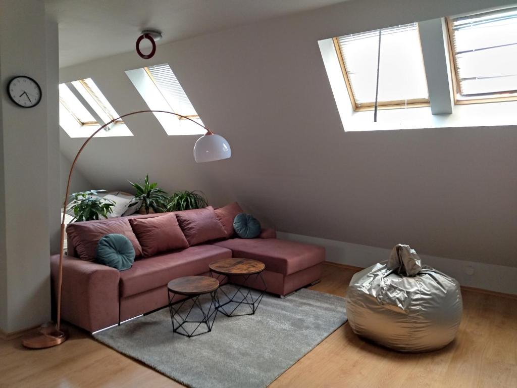 a living room with a pink couch and two windows at Altavista mountain apartment in Samokov