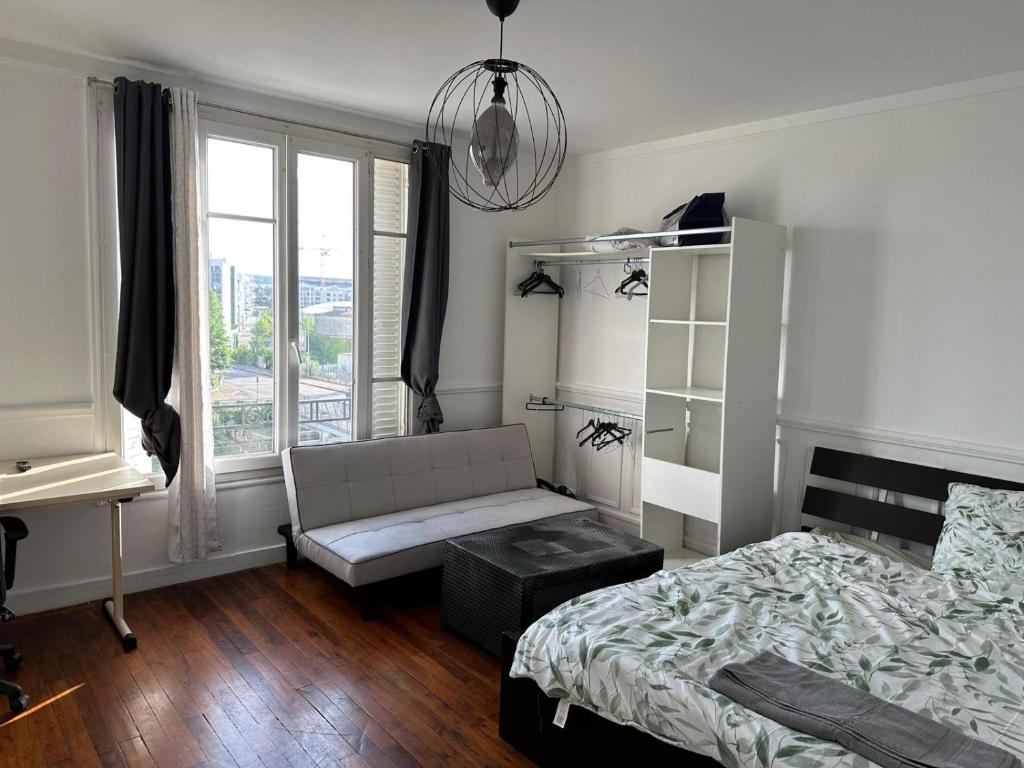 - une chambre avec un lit, un bureau et une fenêtre dans l'établissement Appartement Mantes-la-Jolie, à Mantes-la-Jolie