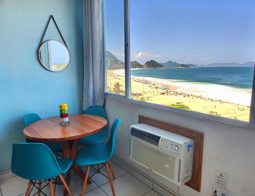 a dining room with a table and a view of the beach at Apto com Vista total da Praia de Copacabana TC802 in Rio de Janeiro