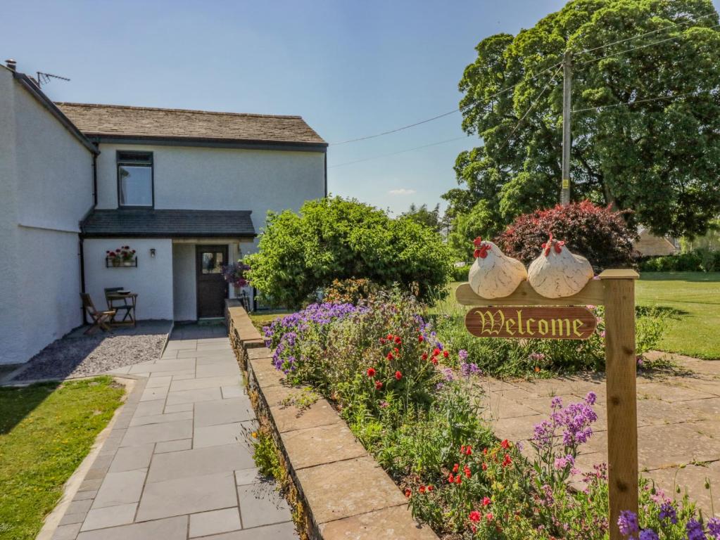 a garden with two bags on a sign in front of a house at How Hill Farm Cottage in Penrith