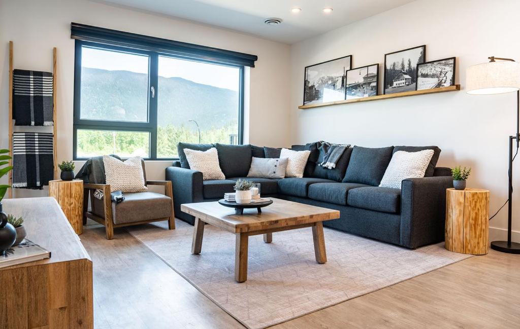 a living room with a blue couch and a table at Ghost Peak by Revelstoke Vacations in Revelstoke