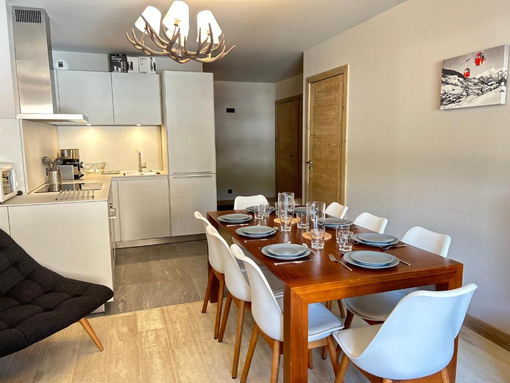 une salle à manger avec une table en bois et des chaises blanches dans l'établissement Appartement Haut Standing au Centre des Gets, Pied des Pistes, 6/8 Couchages, Terrasse, Services Inclus - FR-1-623-89, aux Gets