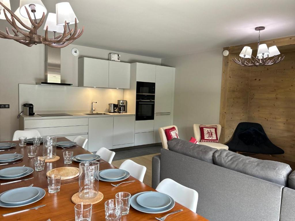 une salle à manger avec une table et une cuisine dans l'établissement Appartement neuf aux Gets, au pied des pistes et du centre, avec terrasse et services inclus - FR-1-623-50, aux Gets