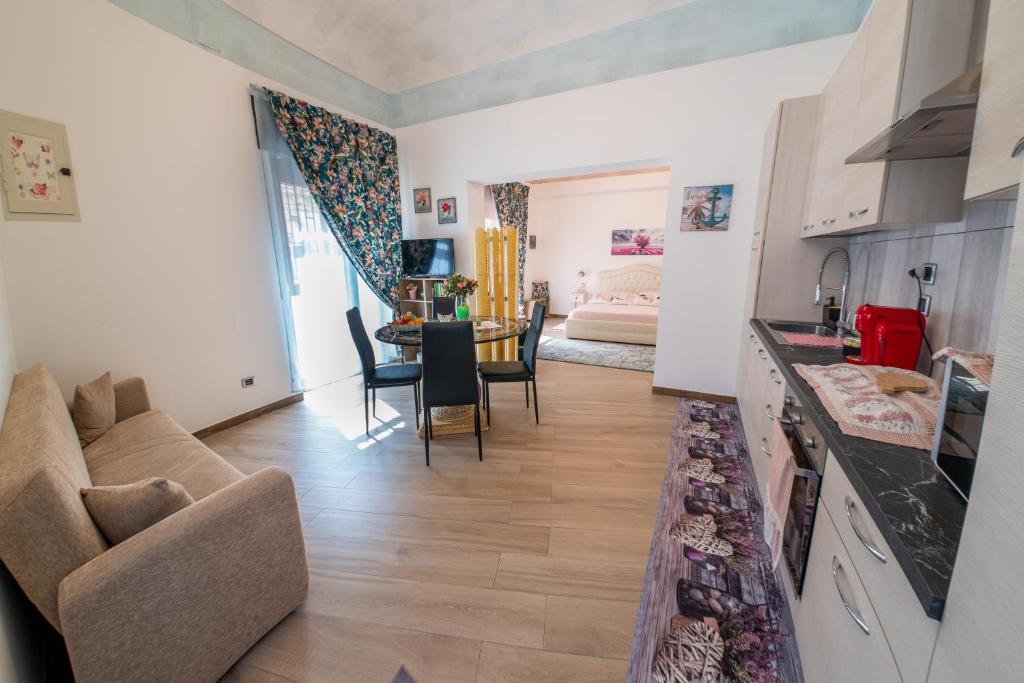 ein Wohnzimmer mit einem Sofa und einem Esszimmer in der Unterkunft ROSE HOUSE in Syrakus