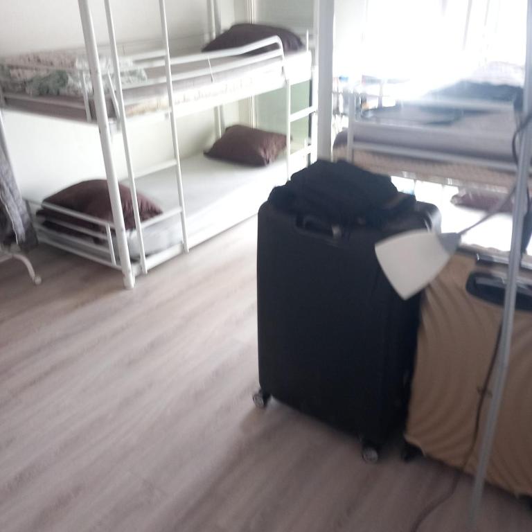 a black suitcase sitting in a room with bunk beds at A 20 minutes de Paris in Sarcelles
