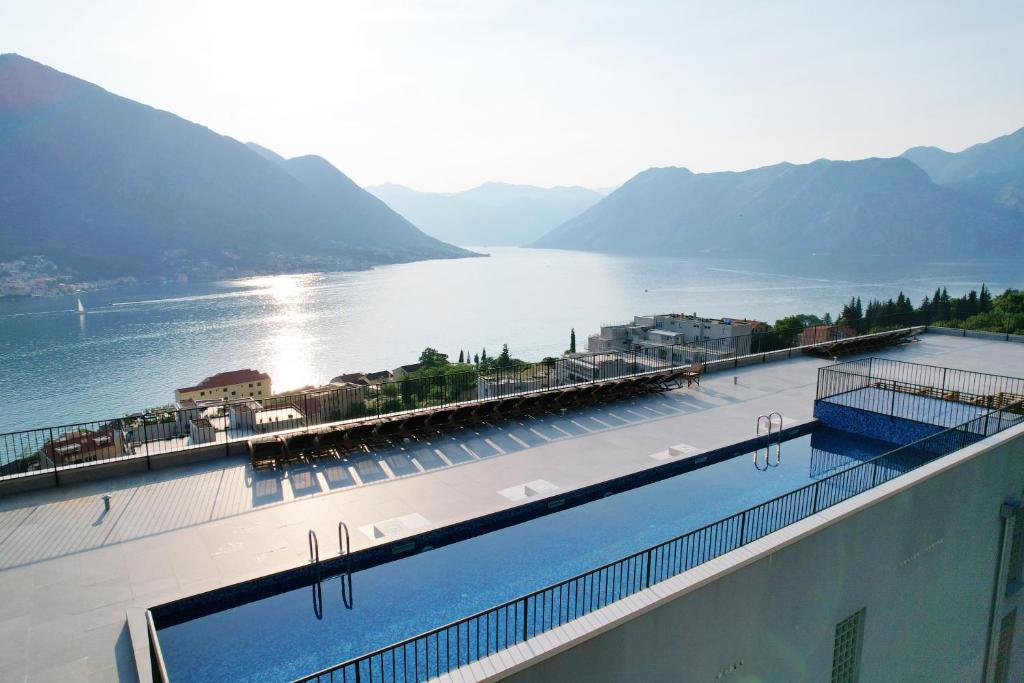 a large swimming pool with a view of a body of water at Hotel Credo in Kotor