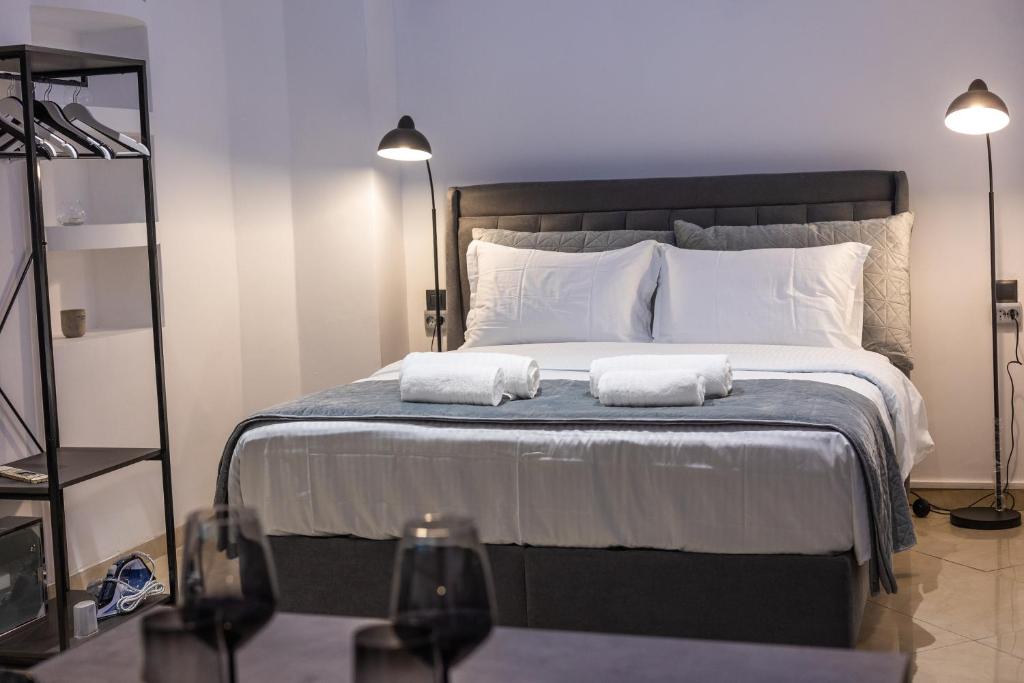 a bedroom with a large bed with two white pillows at Black Suites in Chania Town