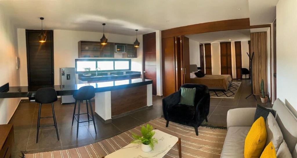 uma cozinha e uma sala de estar com um sofá e uma mesa em Moderno & Comodo Loft Quetzal em Mérida