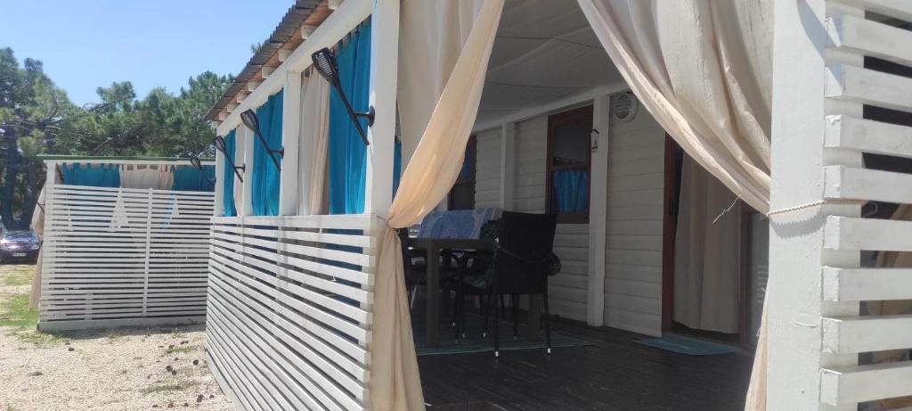 a porch of a house with curtains on it at Mobile Homes Inalex Relax in Privlaka