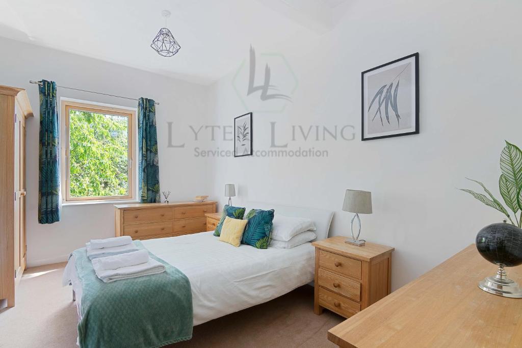 a bedroom with a bed and a table and a window at The Wharf - Oxford City Centre with Garden at Lyter Living Serviced Accommodation Oxford in Oxford