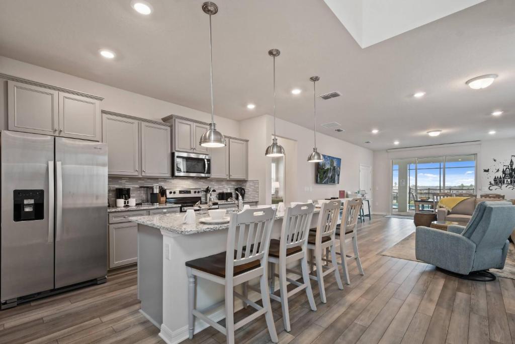 a kitchen with a island with chairs and a table at Luxury Six Bed Four in Bath Windsor Island BSV1707 in Davenport
