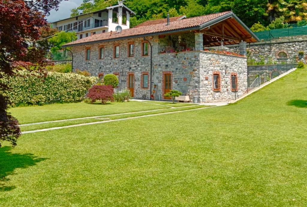 a large stone building with a grass yard at Residenza Jasmine in Verbania