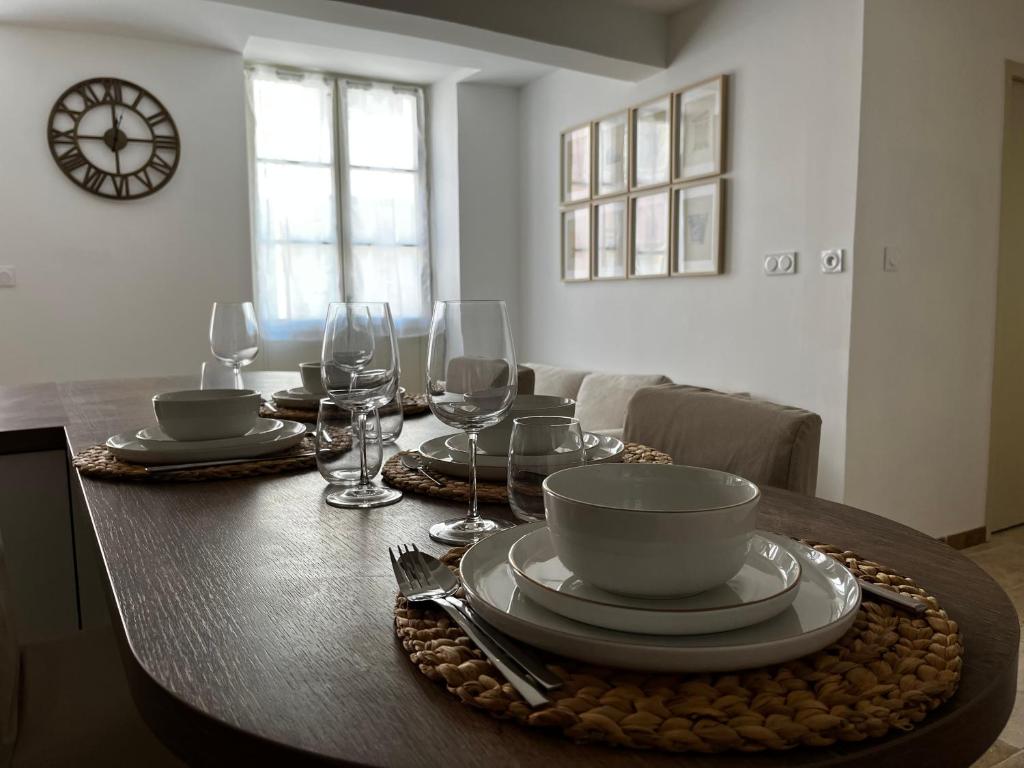 - une table à manger avec des assiettes et des verres à vin dans l&#39;établissement Plein centre - Climatisé - proche cité médiévale, à Carcassonne
