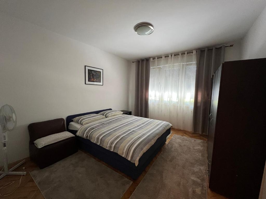 a bedroom with a bed and a chair in it at Apartman Čapljina in Čapljina