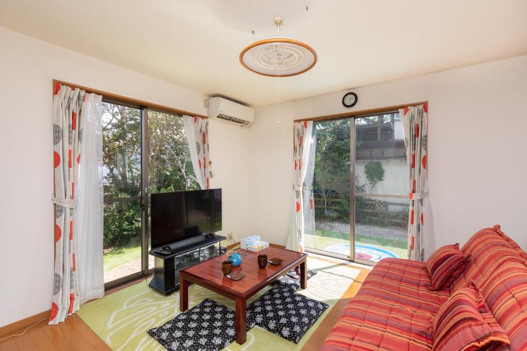 sala de estar con sofá y TV en Hiei Blue Roof - Vacation STAY 13887 en Otsu