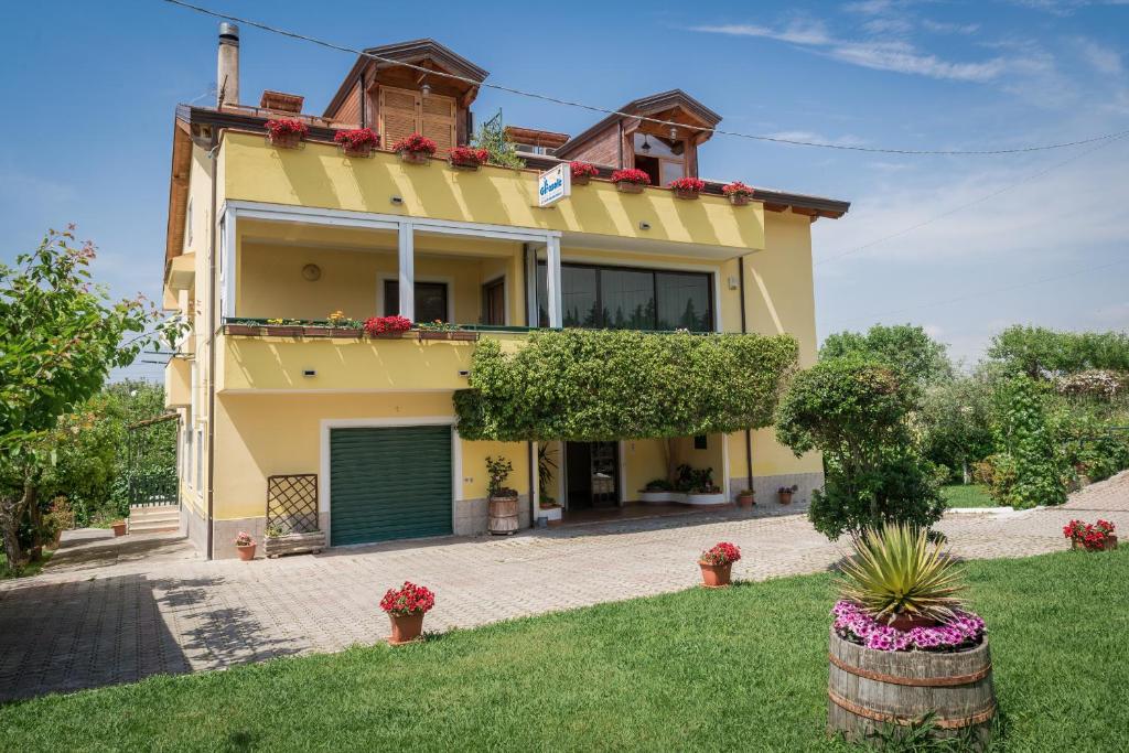 Una gran casa amarilla con un garaje verde en B&B Il Girasole, en Agropoli