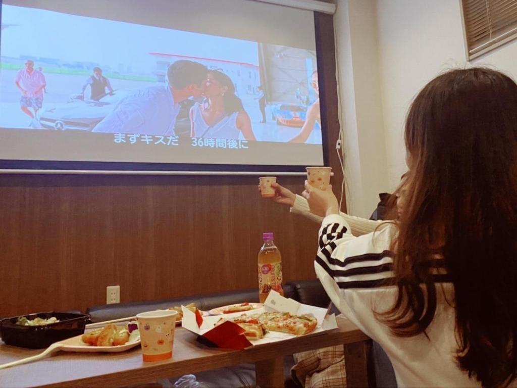 una mujer sentada en una mesa frente a una pantalla en Polar Resort KAWAGUCHI URBAN - Vacation STAY 29860v en Kawaguchi