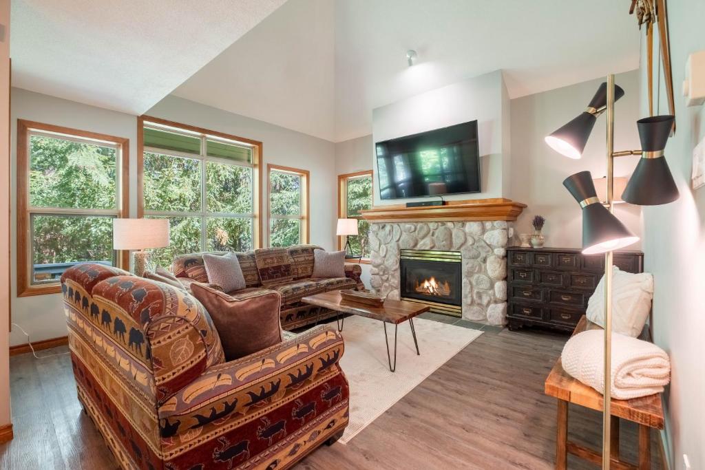 a living room with a couch and a fireplace at Arrowhead Point by Outpost Whistler in Whistler