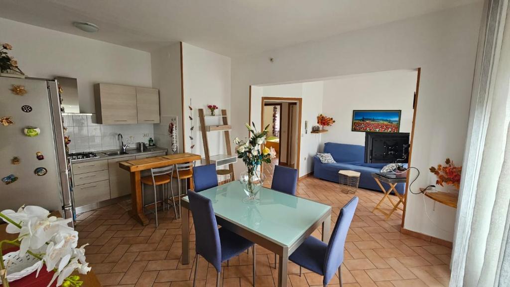 a kitchen and living room with a table and chairs at Delizioso appartamento collinare in Limigiano