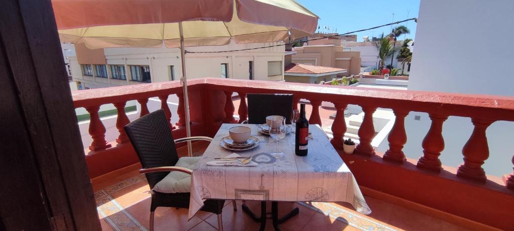 una mesa en un balcón con sombrilla en Las Palmas centro con terraza privada, en Las Palmas de Gran Canaria