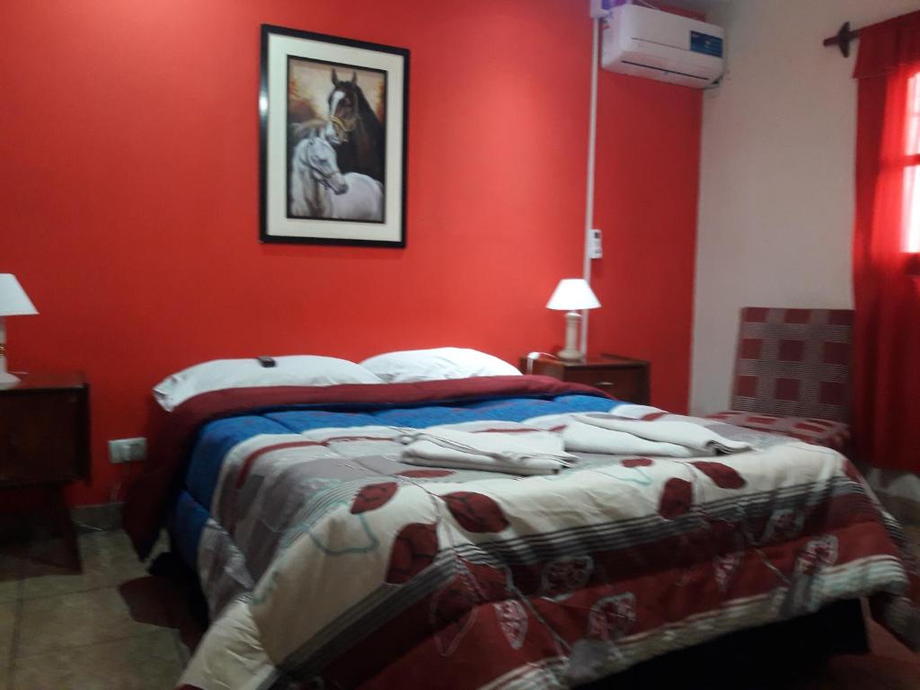 a bedroom with a bed with red walls at Habitaciones BRISA in Salta